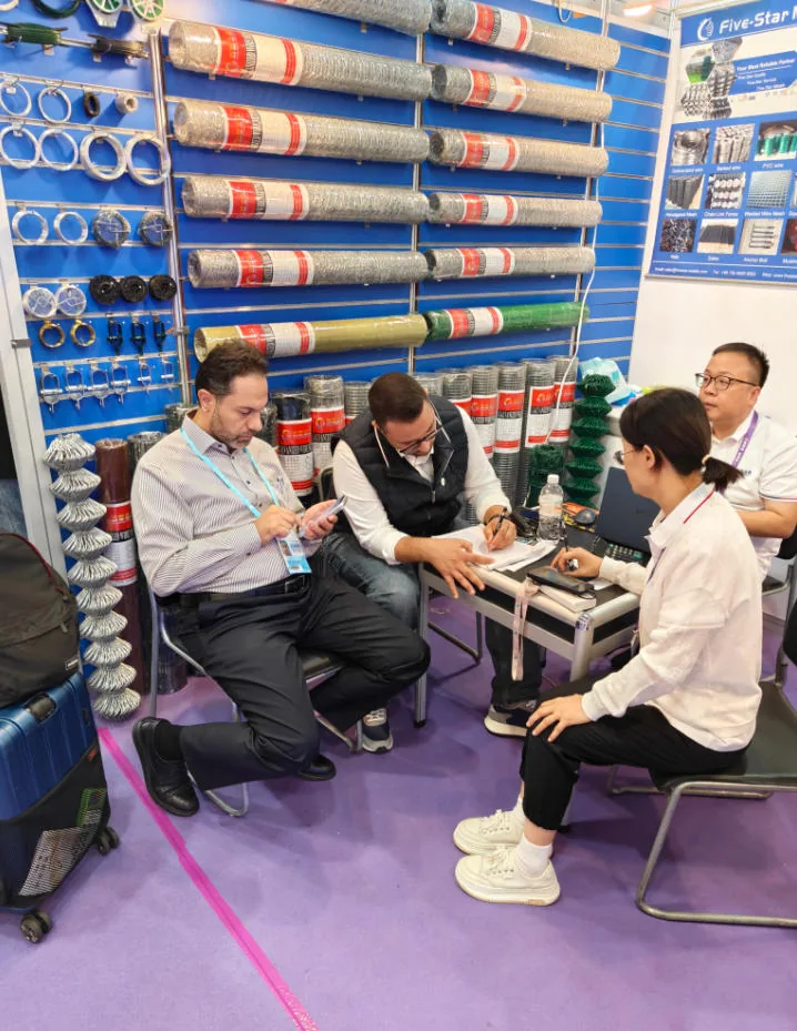 Buyers reviewing a product specification sheet with the Five Star Metal team at Booth 13.1B07